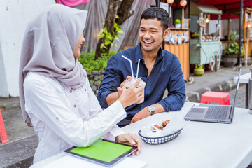 two young Asian business colleagues meet and work together outside the office
