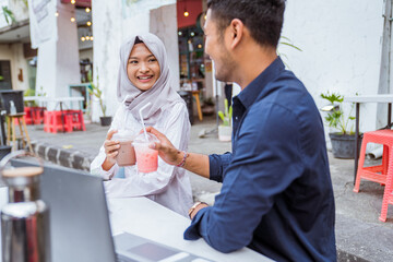 Obraz premium two Asian business partners enjoy a drink together at a coffee shop