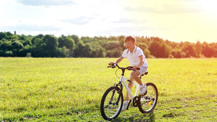 Obraz premium a boy rides a bike in the park