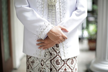 detail of the groom's hand, who is wearing a white dress