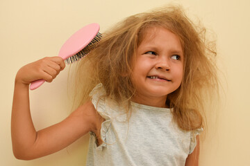 The child tries to comb the thin and very tangled hair with a brush, but it does not work.  Little...