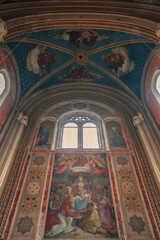 Fototapeta na wymiar Monumental church building in Gothic in neo-romanesque arch style with large ceiling and altar murals and fresco, opulent detailed columns and marble structures