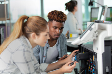 woman and man working on printer