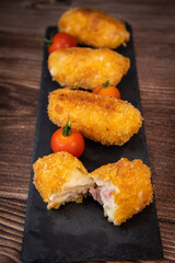 Homemade traditional Spanish croquettes or croquetas on a black plate with fork, Tapas food, High quality photo