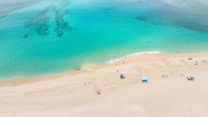 Aerial top view on nature landscape view of beautiful tropical clean sandy beach and soft blue ocean. Aerial top-down drone view.