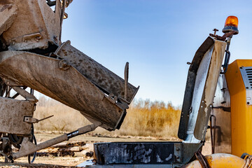 Concrete mixer truck delivers concrete to the pump for pouring piles. Concrete pump at the construction site. Close-up of concrete delivery.