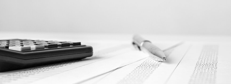 Calculator on financial statement and balance sheeet on desk of auditor. Concept of accounting and audit business.