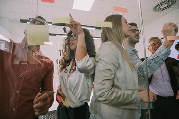 Close up opf business people writing on sticky notes