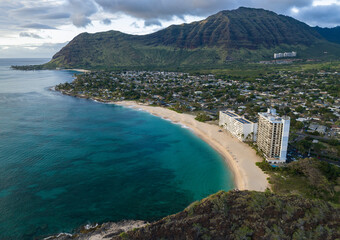 Green Mountains, ocean, and clouds on the west side of Oahu Hawaii at sunset time. Aerial top-down...
