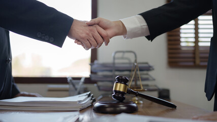 Lawyer consultant shaking hand with client sign contract agreement document in law firm. Business meeting Handshake..