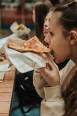 Brunette girl biting delicious slice of pizza. Close up shot