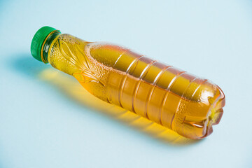 Apple juice in a plastic bottle on a blue background. Concept of earth day, zero waste and plastic...