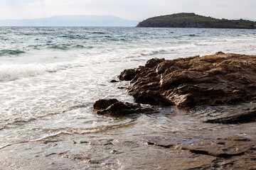 Rocky shore of the Aegean Sea in a cloudy day