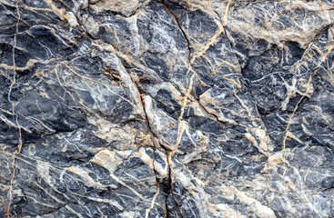 Background of stone texture. Closeup of natural stone surface with cracks.