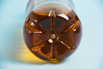 Plastic bottle with drink close-up on blue background. Concept of earth day, zero waste and plastic...