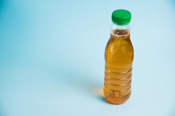Juice in a plastic bottle on a blue background. Concept of earth day, zero waste and plastic recycling.