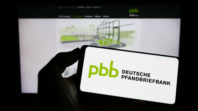 Stuttgart, Germany - 04-01-2023: Person holding cellphone with logo of company Deutsche Pfandbriefbank AG (PBB) on screen in front of business webpage. Focus on phone display.