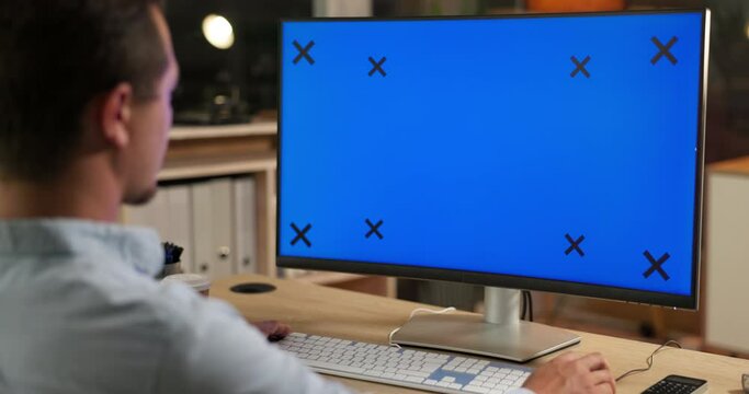 Green screen, computer and man in office online for website, research and internet working at night. Corporate, business and male worker with tracking marker for communication, network and branding