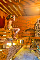 Bath House Ideas. Person in Banya Beating Himself with Birch Twigsin a steam bath in Finnish...