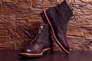 Dark Brown Grain Brogue Derby Boots Made of Calf Leather with Rubber Sole Placed Over Grunge Background.