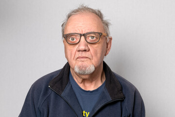 Obraz premium portrait vieil homme avec lunettes ébouriffé sur fond gris