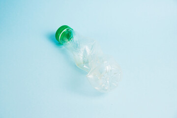Used plastic bottle of juice for a drink on a blue background. Concept of earth day, zero waste and plastic recycling.