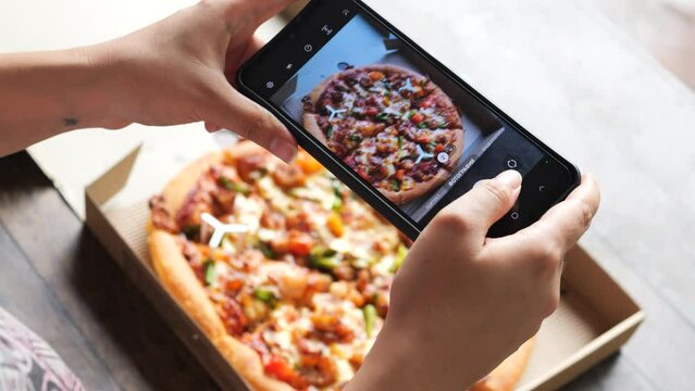 Woman hands taking photos of pizza.