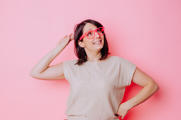 Femme expression en studio avec lunettes rose - obrazy, fototapety, plakaty