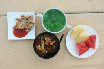 fasting appetizer with sliced fruit, soup, cucumber juice and fried chicken skin