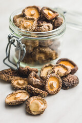 Dried shiitake mushrooms in jar on kitchen table.