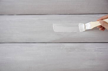 Hand painting a leather headboard with white acrylic paint  brush                          