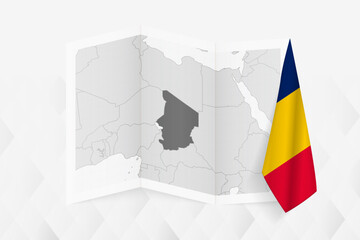 A grayscale map of Chad with a hanging Chadian flag on one side. Vector map for many types of news.