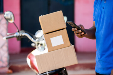 African Delivery Courier Man from Local Postal Shipping Service delivers Mail packages with...