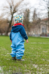 Fototapeta premium A young child in a park at rainy weather