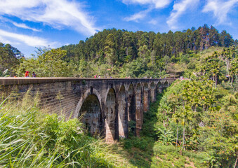 Fototapeta na wymiar An old colonial nine-arch bridge in the jungles of Sri Lanka. Photography for tourism background, design and advertising.m