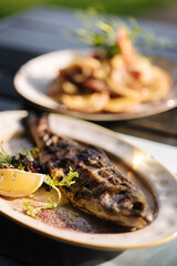 Baked seabass fish in the oven served with slice of lemon and pea sprouts