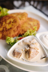 Fried grated potatoes served with mushroom sauce and sour cream. Tasty Ukrainian dish