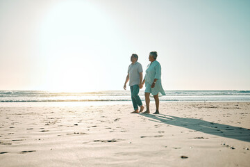 Sunset, mockup and an old couple walking on the beach, holding hands during a romantic date together. Love, nature or bonding with a senior man and woman taking a walk on the coast during summer