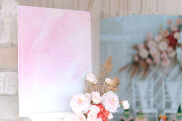 Empty photo display board on stand for wedding arch with flowers background. Copy space for text. Clipping path.