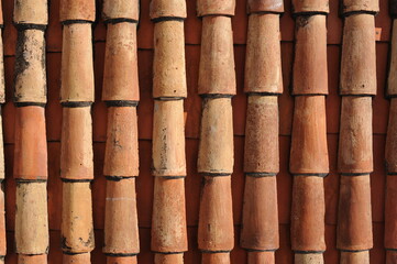 Red and orange roof tiles texture pattern on roof of an old historical building