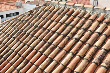Red and orange roof tiles texture pattern on roof of an old historical building