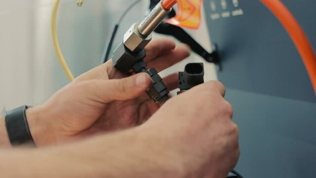 The master installs the fuel injector on the diagnostic stand. Fuel injection equipment repair stand