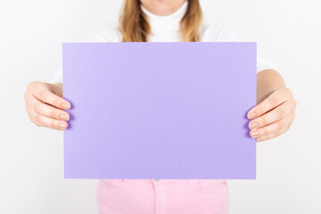 anonymous woman holding a purple paper in her hands. Space for text