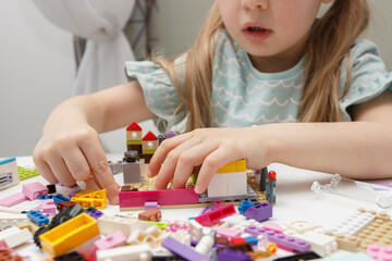 Child builds with constructor bricks, plays with toys