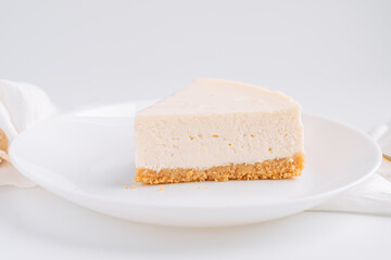 White classic cheesecake on plate on white background with napkin.