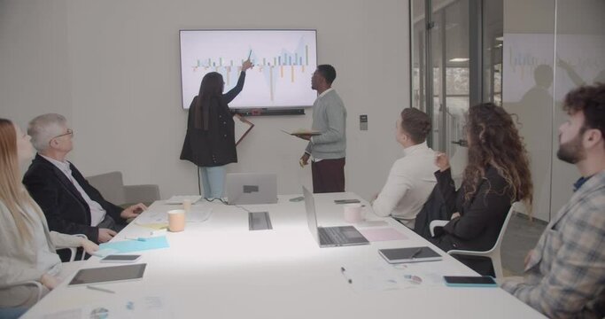 Sales staff presenting the results on a tv screen chart