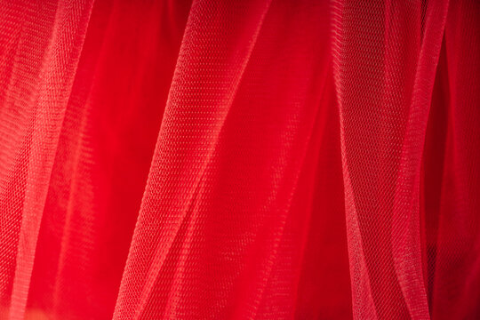 Background of red tulle fabric closeup.