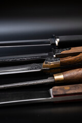 Damascus steel knives on a black background. Kitchen knives. background with japanese knife. A set...