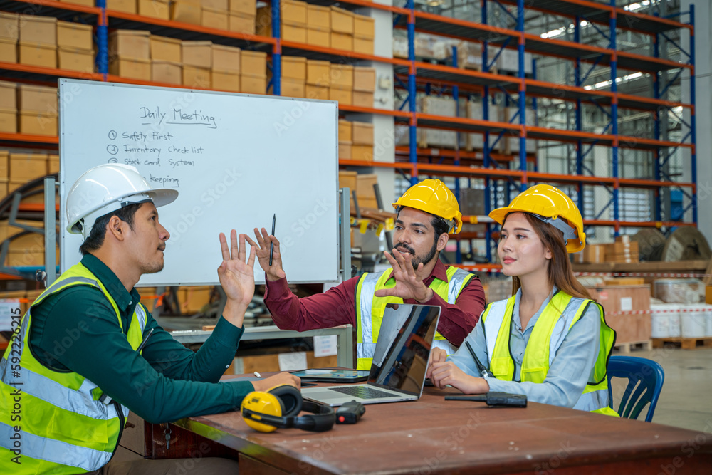 Poster group of warehouse workers have a briefing in a large distribution center,concept of teamwork and oc