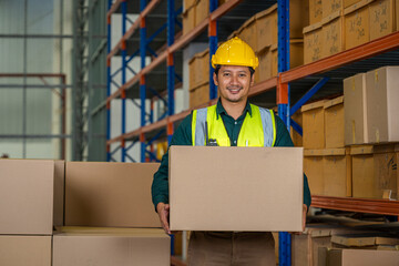 Warehouse employees reading a clipboard in a logistics centre,Warehouse worker taking packages for shipment in a large distribution centre.